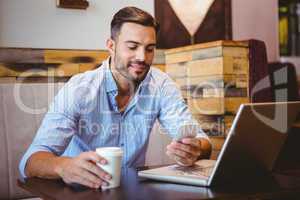 Smiling businessman sending a text message