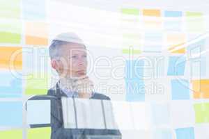 Puzzled businessman looking post its on the wall