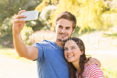 Cute couple doing selfie in the park