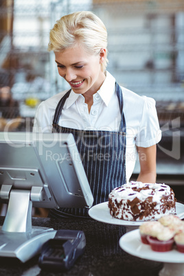 Smiling employee using calculator on counter