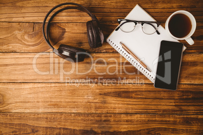 Pen glasses on the smartphone on notepad next to cup of coffee a