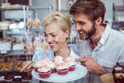 Cute couple on a date pointing chocolate cakes