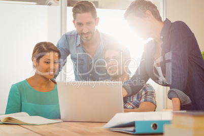 Colleagues using laptop at office