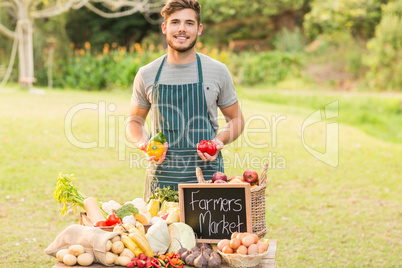 Handsome farmer holding peppers