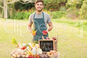 Handsome farmer holding peppers