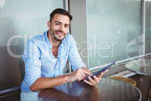 Smiling businessman using a tablet