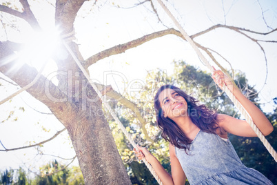 Pretty brunette swinging in park