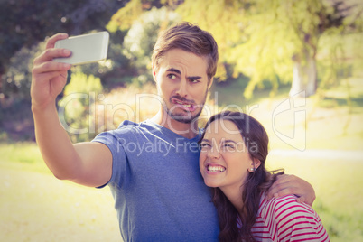 Cute couple doing selfie in the park