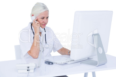 Doctor working on her laptop and calling