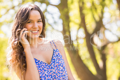 Pretty brunette having phone call in the park