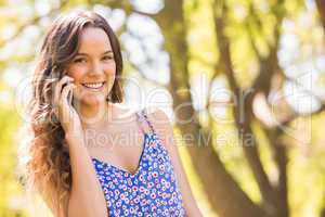 Pretty brunette having phone call in the park