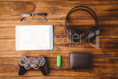 Tablet and glasses next to joystick music headphone and wallet