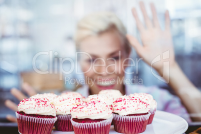 Astonished pretty woman looking at cup cakes