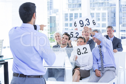 Smiling business team showing paper with rating