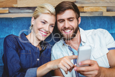 Cute couple on a date watching photos on a smartphone