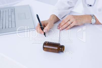 Doctor writing on a notepad