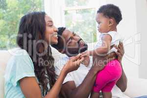 Happy couple with their baby girl on couch