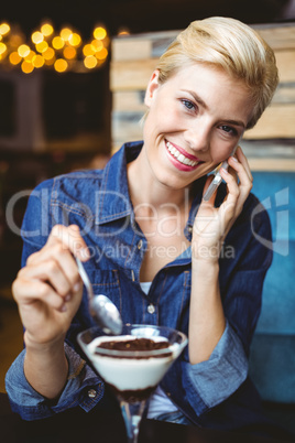 Smiling blonde eating a creamy chocolate