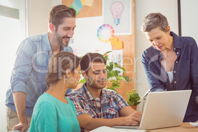 Colleagues using laptop at office