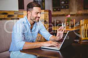 Smiling businessman using his laptop