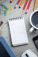 Notepad next to the cup tablet smartphone and mouse