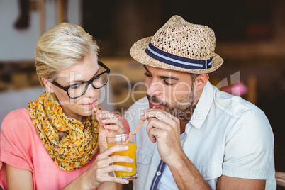 Cute couple on a date sharing an orange juice