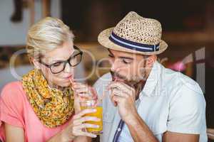 Cute couple on a date sharing an orange juice