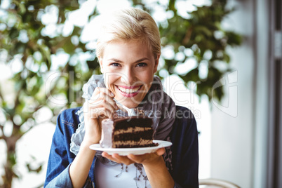 Smiling blonde taking a piece of chocolate cake