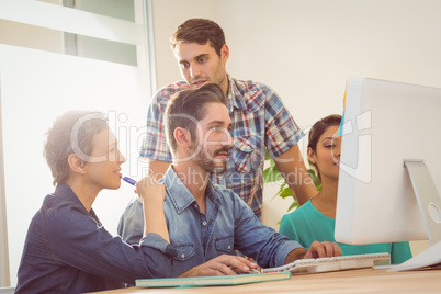 Colleagues using laptop at office