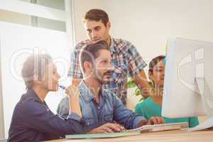 Colleagues using laptop at office