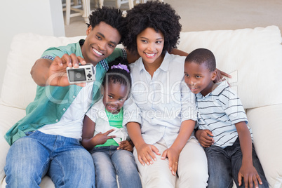 Happy family taking a selfie on the couch