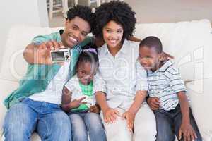 Happy family taking a selfie on the couch