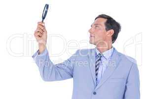 concentrated businessman using magnifying glass