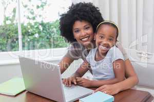 Happy mother and daughter using the laptop