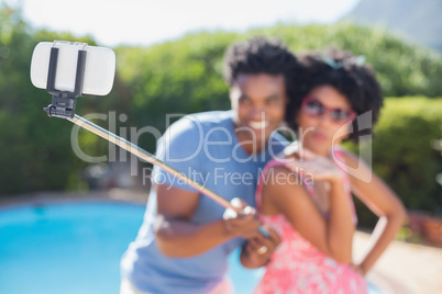 Happy couple using a selfie stick Happy couple using a selfie stick