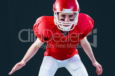 A serious american football player taking his helmet looking at