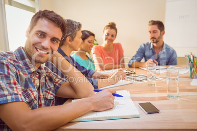 Casual businessman smiling at camera during meeting