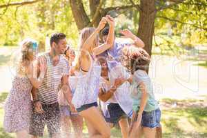 Young friends having fun with hose in the park