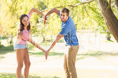 Cute couple doing heart shape with their hands