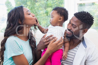 Happy parents with baby girl on couch