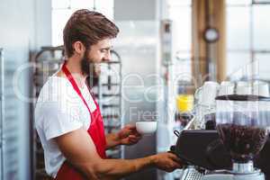Handsome barista using the coffee machine