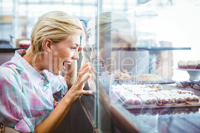 Astonished pretty woman looking at cup cakes