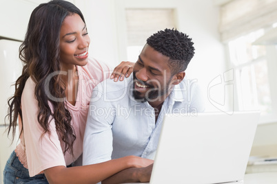 Happy couple using their laptop