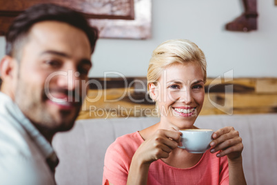 Couple with coffee cup sitting on sofa