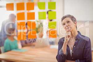 Concentrated businesswoman looking post its on the wall