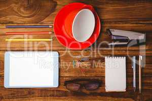 Tablet next to cup and notepad