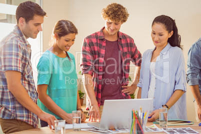 Happy creative business team using laptop in meeting