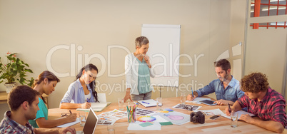 Casual businesswoman giving presentation to her colleagues