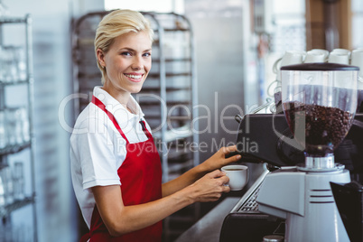 Pretty barista using the coffee machine