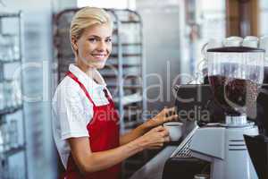 Pretty barista using the coffee machine